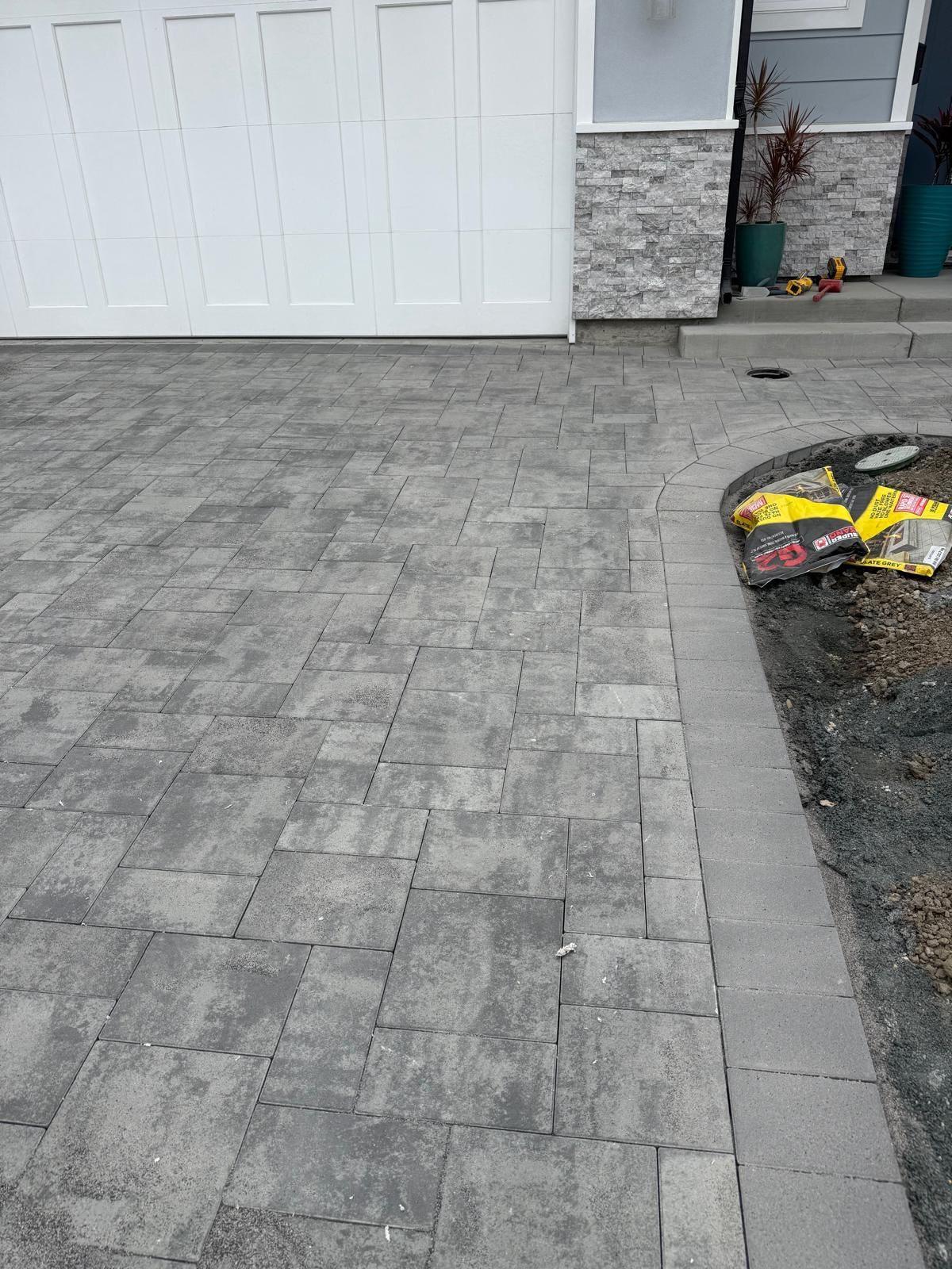 Finished paver walkway and planting bed running up to the garage and front door